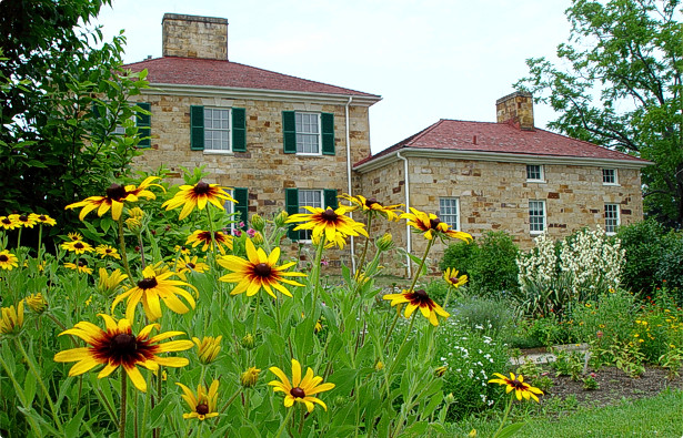 A picture of the Adena mansion to this day with sunflowers captured in the image.