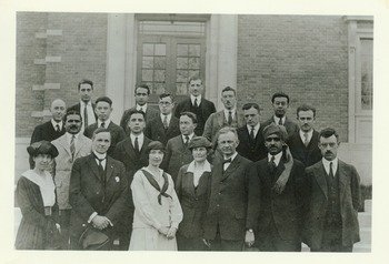 Kenyon L. Butterfield, 1922. Caption of rear of photo says, "College Cosmopolitan Club. 10 nationalities represented. About 1922". Butterfield is in the front row center right.