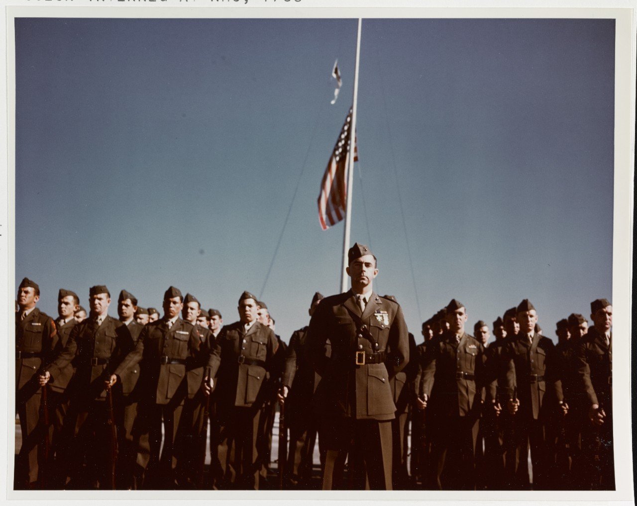 A detail of NAS Marines ranked before the station's flag at half mast a few days after the death of President Franklin Roosevelt, 15 April 1944 (NHHC).
