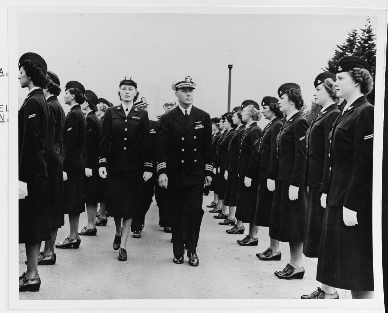 Commander R.L. Smith inspects the NAS's complement of WAVES with Lieutenant Jean Fontain, USN(W) in August 1949 (NHHC).