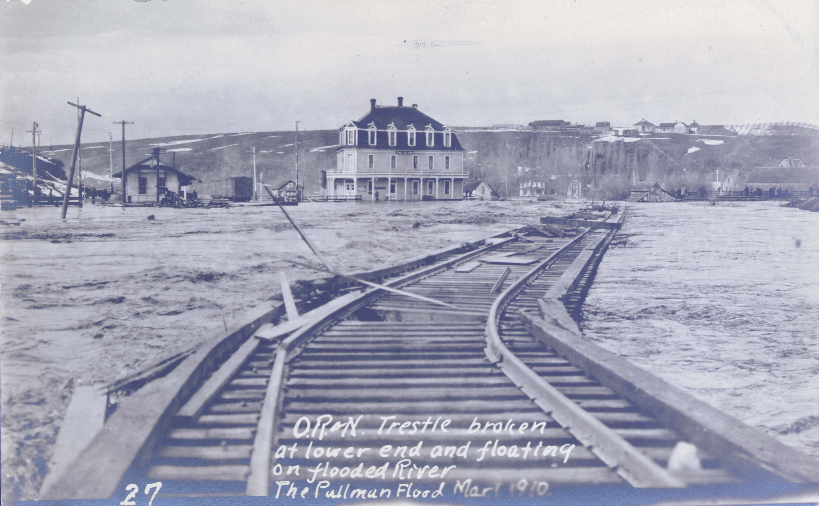 Looking west at the former Union Pacific Depot, with the Oregon Railroad & Navigation Trestle broken at the lower end and floating in flooded Palouse River in 1910. Taken by Robert Burns. Courtesy WSU Special Collections. http://content.libraries.wsu.edu/