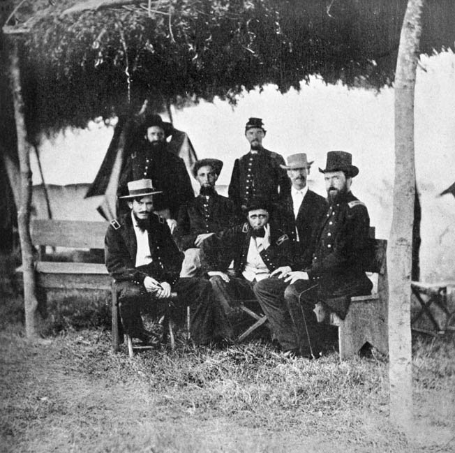 Grierson, seated center with hand on chin,surrounded by his staff.

