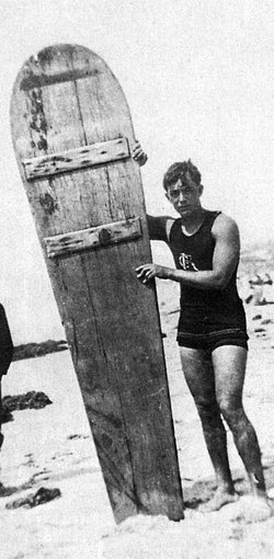 George Freeth posing with his 8 ft., 200 pound wooden surf board