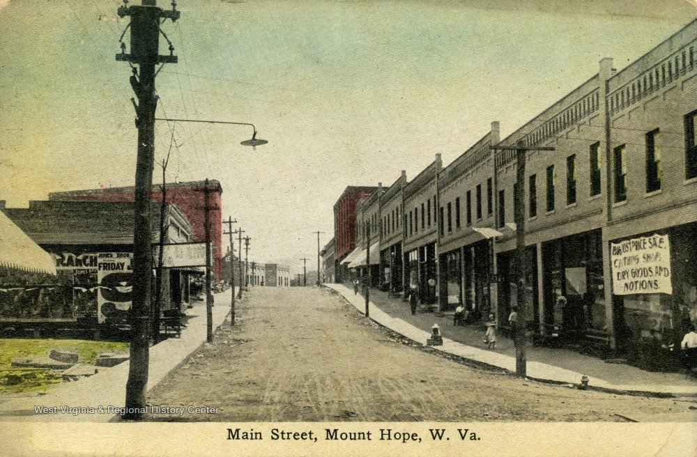 Postcard showing Garret and McNabb Block newly rebuilt. Rubble from post fire can still be seen on the West side of Main St. Ca. 1912.