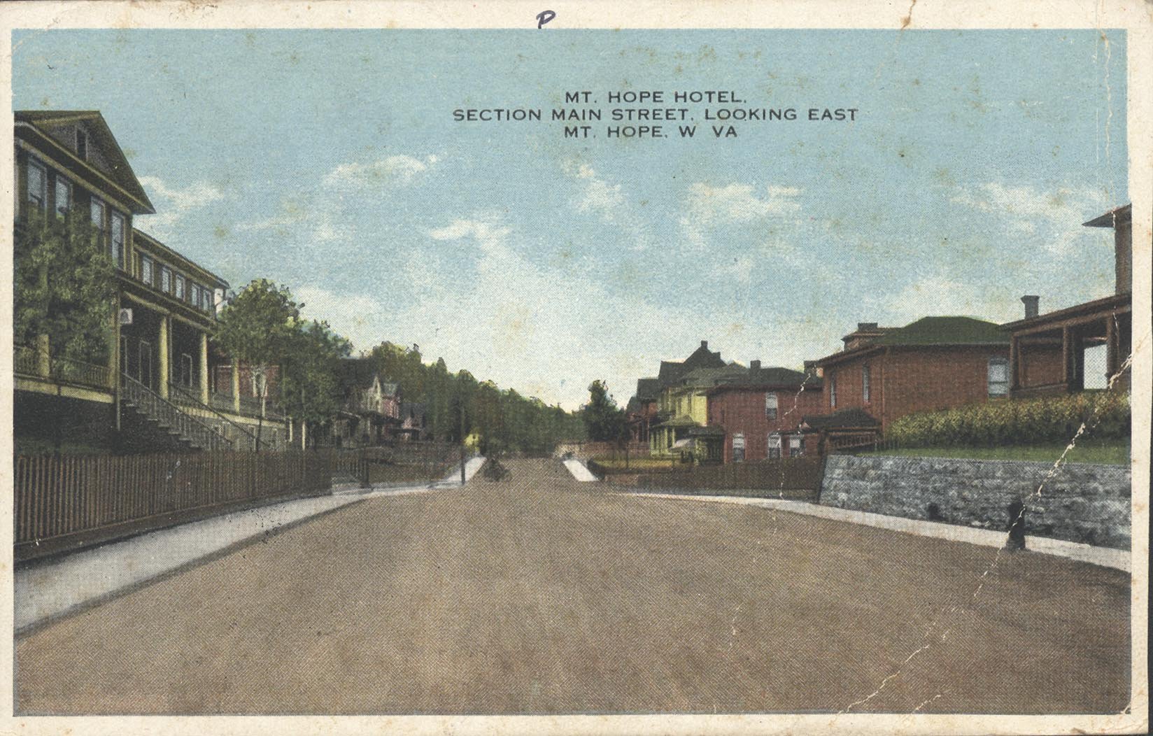 Post card of street view of the former Mount Hope Hotel (left) now known as the Mountainair Hotel. Notice how the porch is elevated away from Main St.