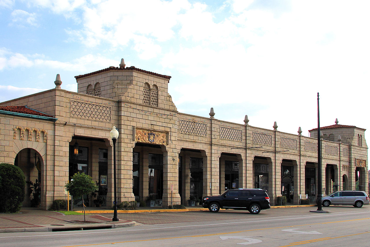 The commercial building features three towers and an arched arcade. 