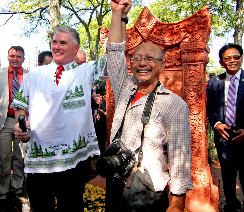 "Lowell City Councilor Rodney Elliott and Cambodian native and Lowell artist, Yary Livan raise arms in celebration after unveiling of the Khmer Monument that Livan designed."
THE SUN Photo by David H. Brow