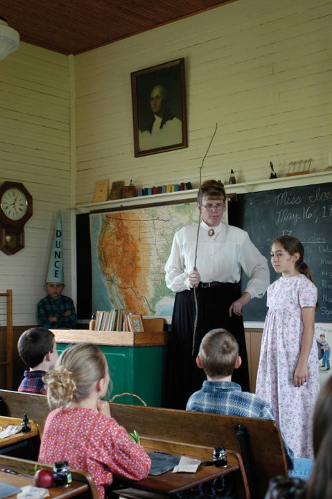Patty Cooper, playing New Era School Marm with a student during the interactive tour.
