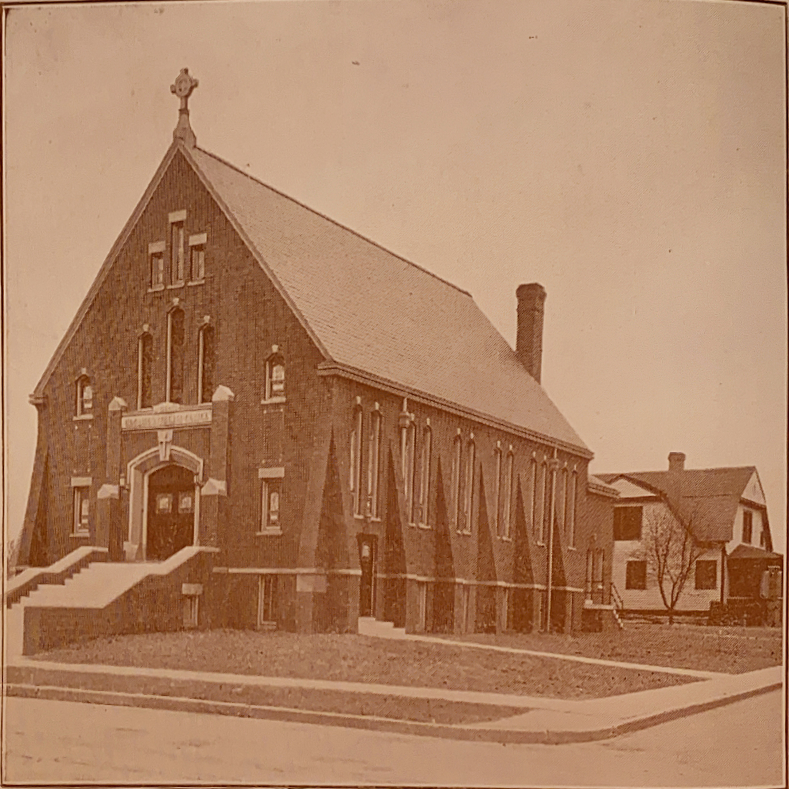 The first unit of the current structure was dedicated in 1922, and could seat 425 adults and their children. In the background, the newly-constructed church parsonage is visible.