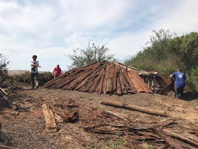 Visitors inspect the pit house, which typically would have been reserved for influential families within the tribe. Tule huts were more common. The Ohlone village can be visited by special appointment (Coyote Hills Facebook).