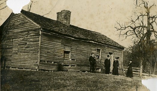 Four unidentified individuals gather at the original Academy building, early 20th century.