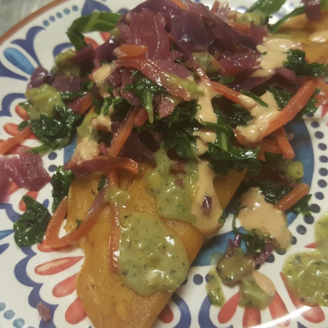 Vegan and gluten free Honduran empanadas stuffed with soy chorizo and potatoes and topped with pickled cabbage, kale salad, and spicy avocado sauce. Picture courtesy of Chef Yari Vargas (casayari).
