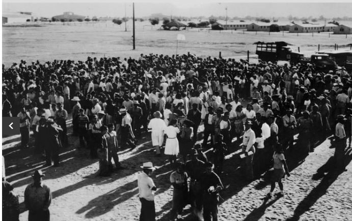 Japanese-Americans behind barbwire fence in the facility.  