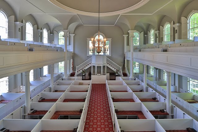 The interior of the church with box pews and high pulpit.