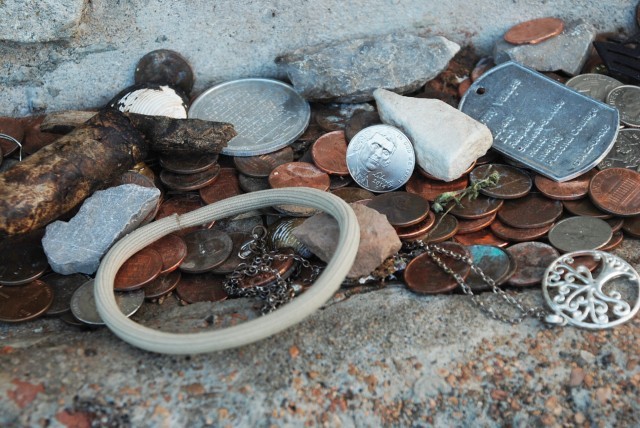 An example of some of the trinkets that are often left at the grave site. This includes jewelry, coins, cigars, dog tags, and more.