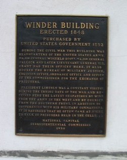 A 2008 photo of the initial historical marker plaque on the side of the Winder Building. The plaque mistakenly claims that President Lincoln used to visit the building to speak with Confederate prisoners. New research shows the building never housed prisoners.