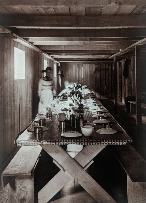 Photo taken by William T. Clarke. The interior of a dining room set up for dinner.