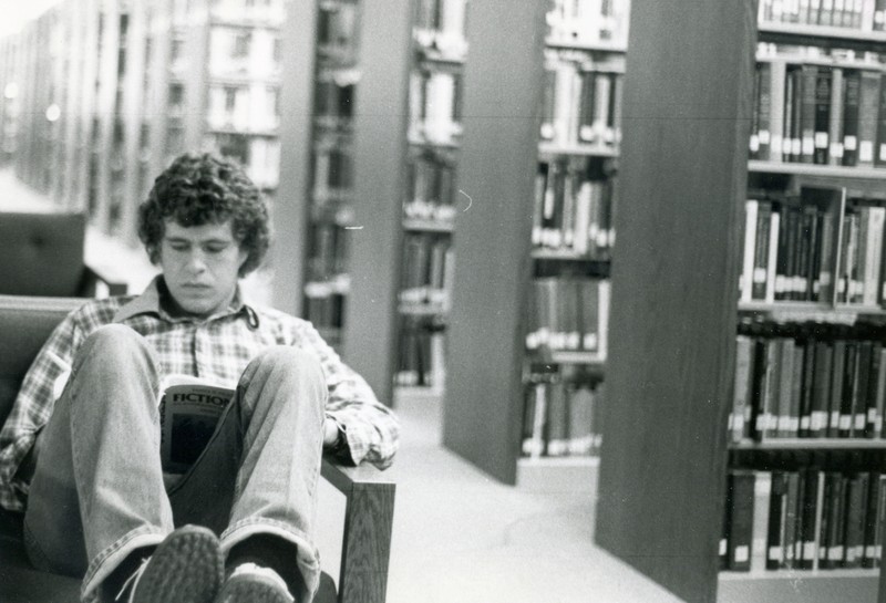 Student studying in the stacks, undated