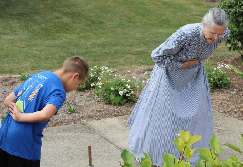 School marm teaching students how to bow