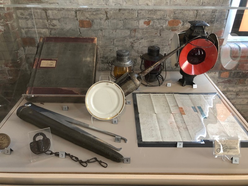 Artifacts from the B&O, including a journal of railroad employee correspondence, a travel pass, payroll ledgers, lanterns, calipers, and a plate from the Capitol Limited line of the B&O.