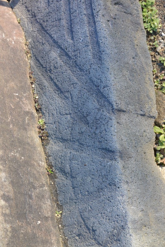 Image of a millstone section with visible furrows being used as a step.