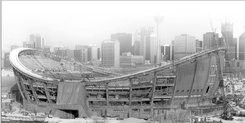 This photograph captures the construction of the Saddledome in 1982, shortly after its opening in 1983. Its saddle-shaped dome reflects the “cowboy” identity of the city of Calgary and acts as a distinctive structure among the city’s skyline. Furthermore, the image emphasises the massive scale of the building as opposed to its skyscraper counterparts by placing the Saddledome at the forefront of the frame. Evidently, the Saddledome is an impressive and important infrastructure in the composition of Calgary as a city.