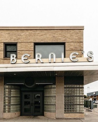 Yellow and glass brick building with "Bernie's" sign above the aluminum awning.