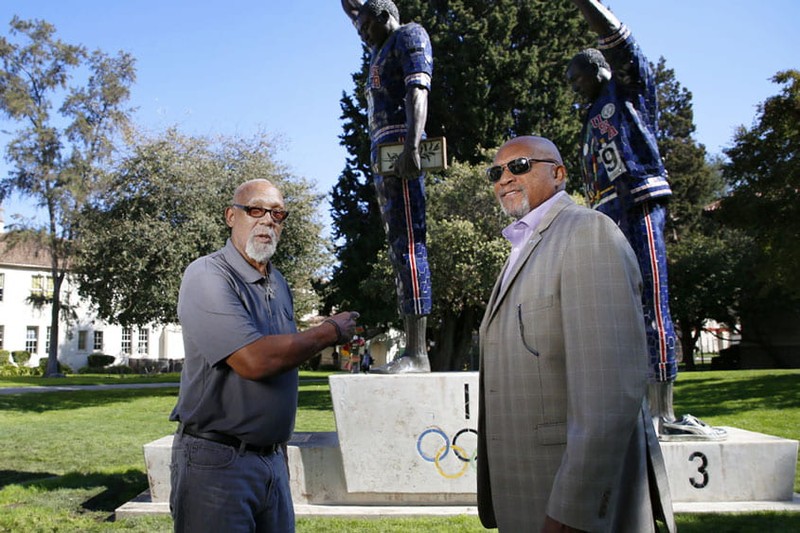 Tommie Smith & John Carlos standing in front of their statue at SJSU.