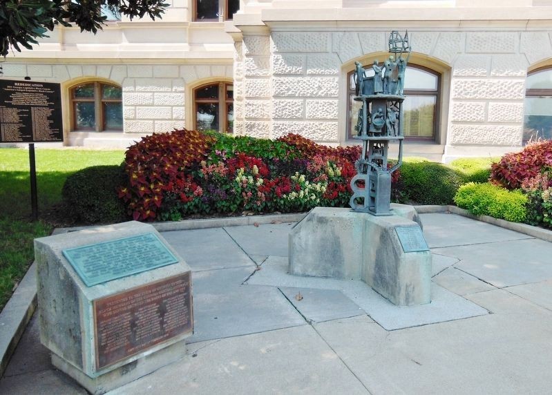 Photograph of historical marker, dedication plaque, and statue.