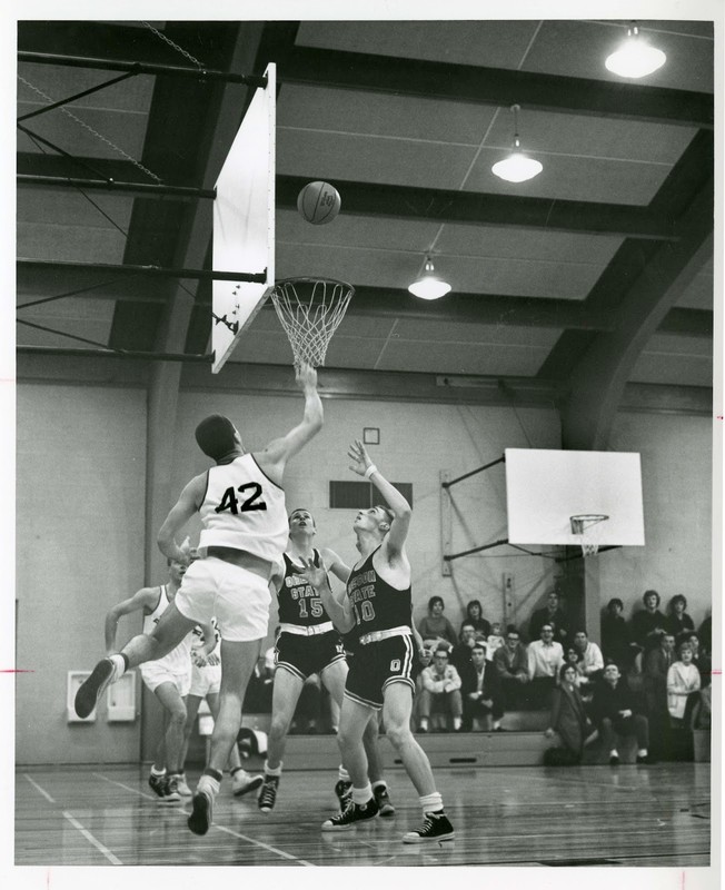 Freshman medical student Jack Gambee (#42) and the medical-dental varsity team play unidentified Oregon State team in front of onlookers in the Student Activities Building gym, circa 1960s.