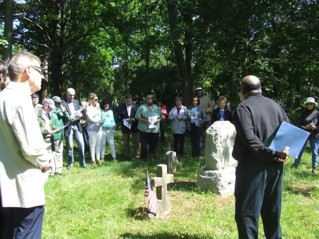 A group gathered at the cemetery to honor the deceased veterans.