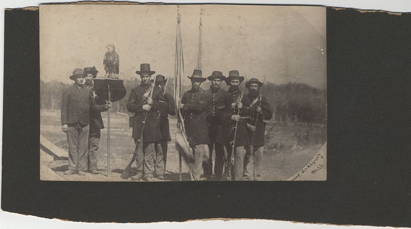 Photograph of the 8th Wisconsin Infantry Regiment Color Guard, taken after the Siege of Vicksburg. Left from right are Homiston, unidentified, Armitage, Dickersheid, McLain, Reily, Pitwch, and unidentified