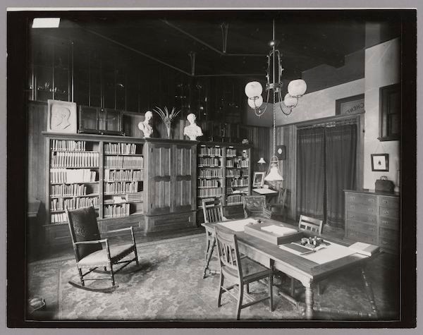 Black & White. Central table surrounded by chairs. Wall to Wall bookcases.