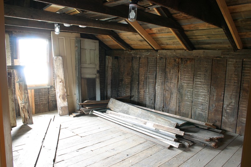 The interior of an old-looking room with exposed rafters. 