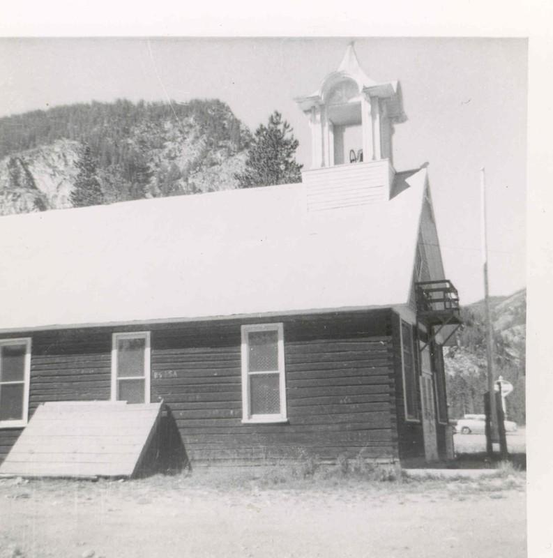The Frisco Schoolhouse, circa 1956. Note the flag pole and the balcony above the front doors.