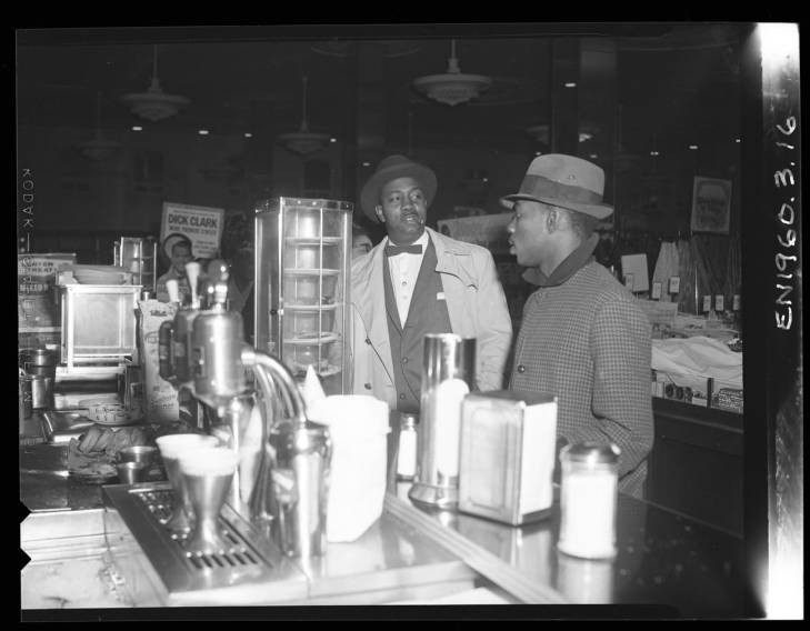 Two men standing at lunch counter