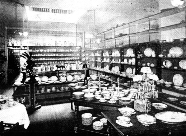 A black and white photo, which is a view store displays of fine Haviland China.