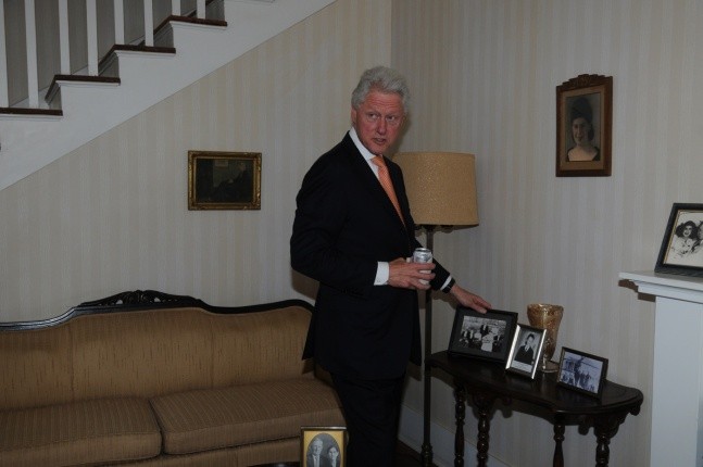 President Clinton Looking at Old Family Photos in the Living Room of the Birthplace Home