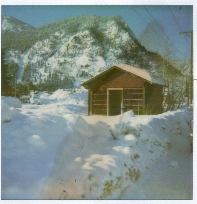 This undated photo depicts the Trapper's Cabin prior to its move to the Frisco Historic Park. You can see Mount Royal in the background and the large drifts of snow in front of the structure.