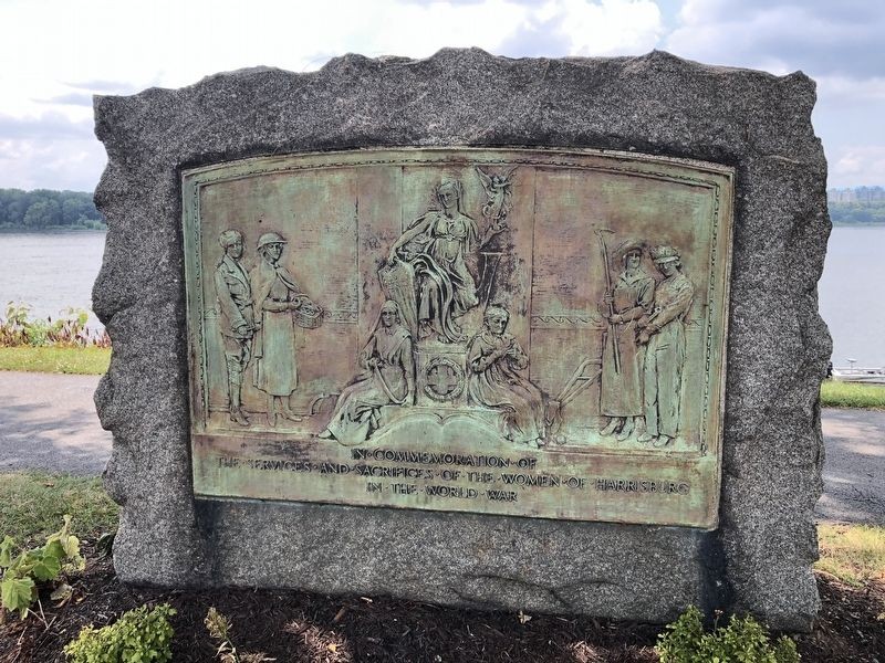 This is a picture of the Women’s WW1 memorial in Harrisburg. Notice the stains and fading details with age. You can also see all 8 women depicted in the monument each wearing job specific clothing with one draped in gowns in the center on the chair holding a small angel in her hand. 