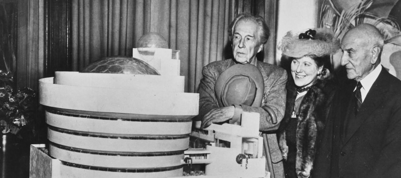 From left to right; Frank Lloyd Wright, Hilla Rebay, and Solomon R. Guggenheim stand with a model of the Guggenheim Museum. Photo taken 1945.