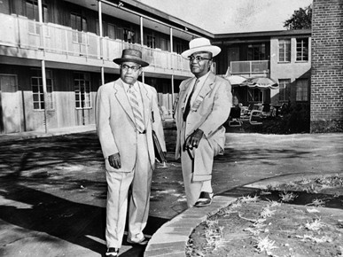 A. G. Gaston (right) stands outside of his motel in 1957.