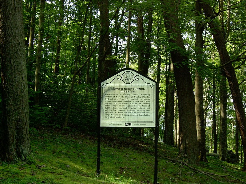 Historical marker related to the Hawks Nest Tunnel Disaster, one of the worst industrial disasters in American history. According to a historical marker on site, there were 109 admitted deaths. A Congressional hearing placed the death toll at 476