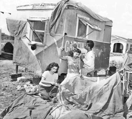 Siblings, Esther, Consuelo, and Raymundo Garcia prepare the tent and caravan for the 1947 season. 