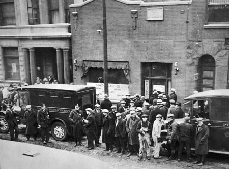 Police and onlookers in front of the SMC Cartage Company following Capone's massacre of rival gang members.