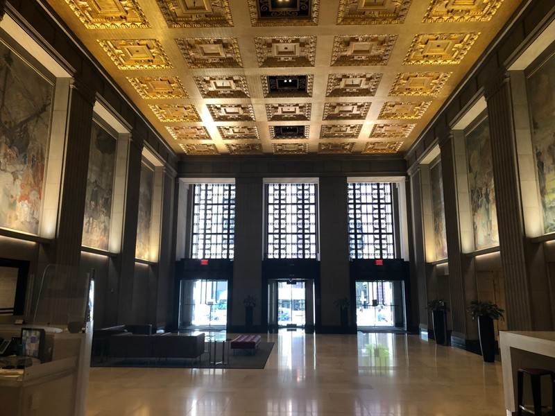 Triple Bronze & Glass doors to the outside. Large, ornate, rectangular transom bronze & glass above each door.