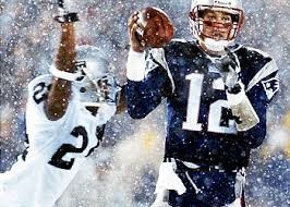 Tom Brady attempting a pass as an Oakland Raiders defender is about to hit him.  This is the play that led to the game being known as "The Tuck Rule Game".