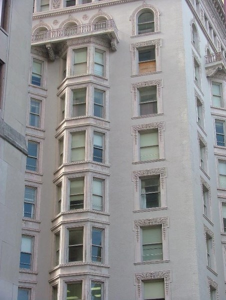 This photo focuses on the Hennen Building's unique bay windows and the balcony that sits atop them.  