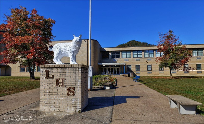 In front of the school, sits the statue of the wildcat. The wildcat serves as the mascot of Logan High School. The lettering underneath shows the colors of the school - blue and gold. 


Source: WV Record