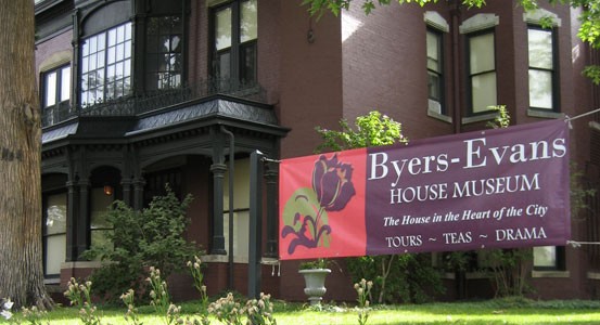 Front of the home with a banner displaying just some of the events held there: tours, dramas, and dinners.